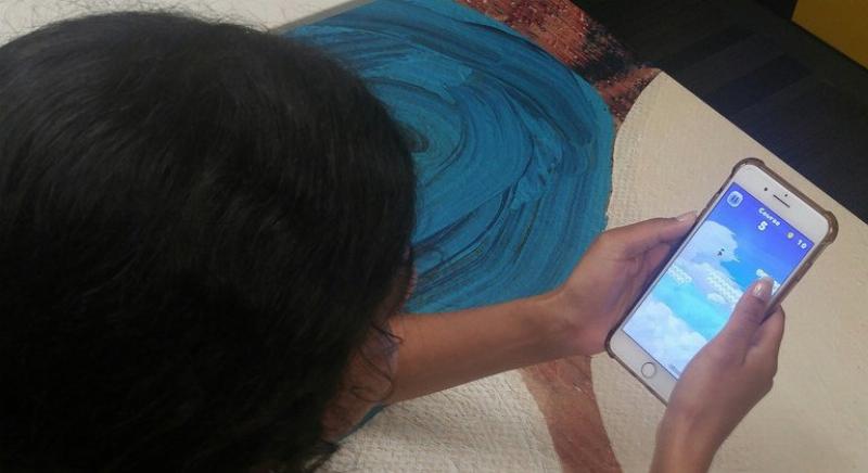 Une jeune femme utilise son téléphone pour écouter de la musique gratuitement avec des écouteurs.